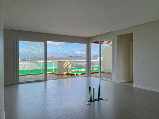 Sala ampla com vista para a área externa e paisagem.