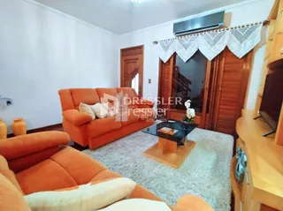 Sala de estar com sofá laranja e piso claro.