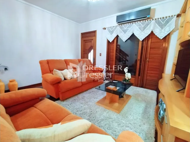 Sala de estar com sofá laranja e piso claro.