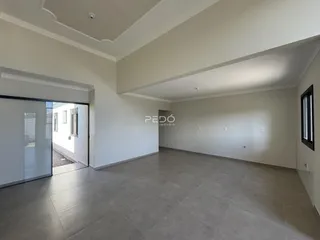 Vista ampla de um ambiente interno com piso de cerâmica e paredes brancas.