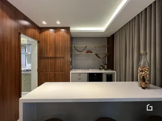 Cozinha moderna com armários de madeira e bancada branca.