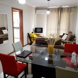 Foto de uma sala de estar com mesa de vidro.