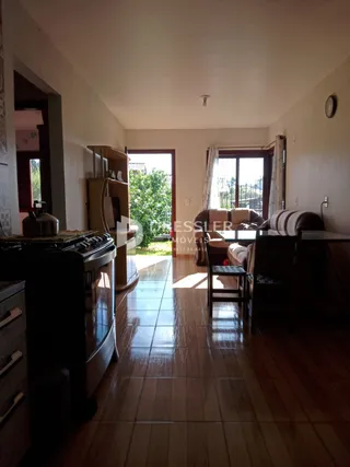 Sala de estar com piso de madeira e porta de entrada para o exterior.