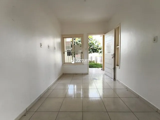 Corredor interno com piso de cerâmica claro.
