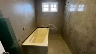 Banheiro com banheira e paredes revestidas de azulejo.