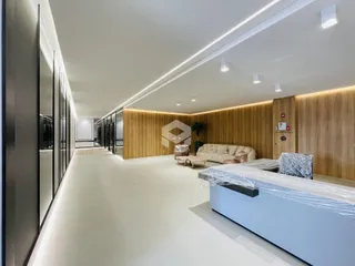 Corredor moderno com revestimento de madeira e área de estar em um apartamento.