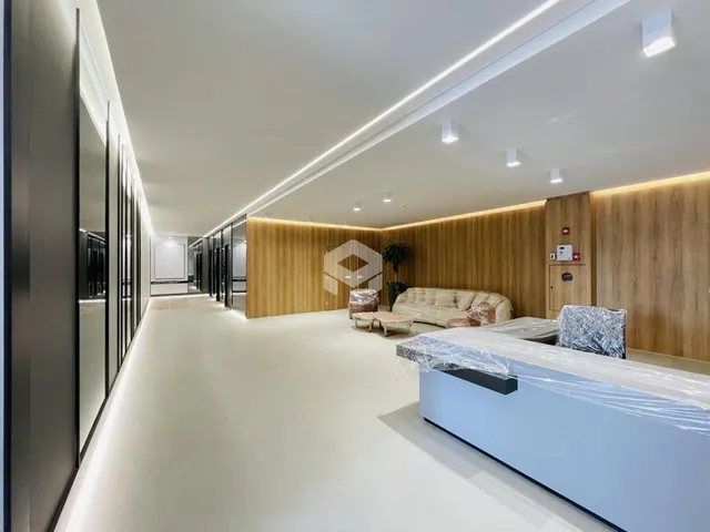 Corredor moderno com revestimento de madeira e área de estar em um apartamento.