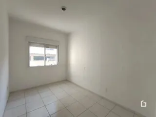 Interior de uma sala com piso de cerâmica e janela.