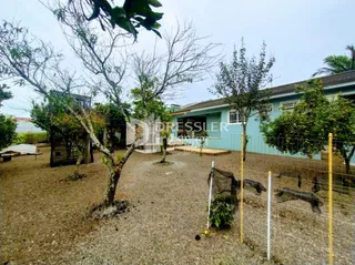 Vista externa de um terreno com vegetação e cerca de madeira.
