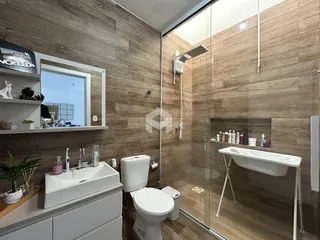 Foto de um banheiro moderno com box de vidro e revestimento de madeira.