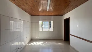 Sala de estar com piso de cerâmica e teto de madeira.
