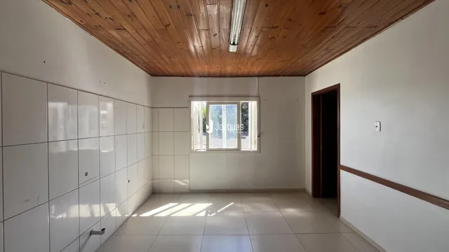 Sala de estar com piso de cerâmica e teto de madeira.