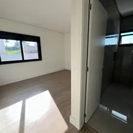 Foto de um cômodo interno com piso de madeira e uma janela.