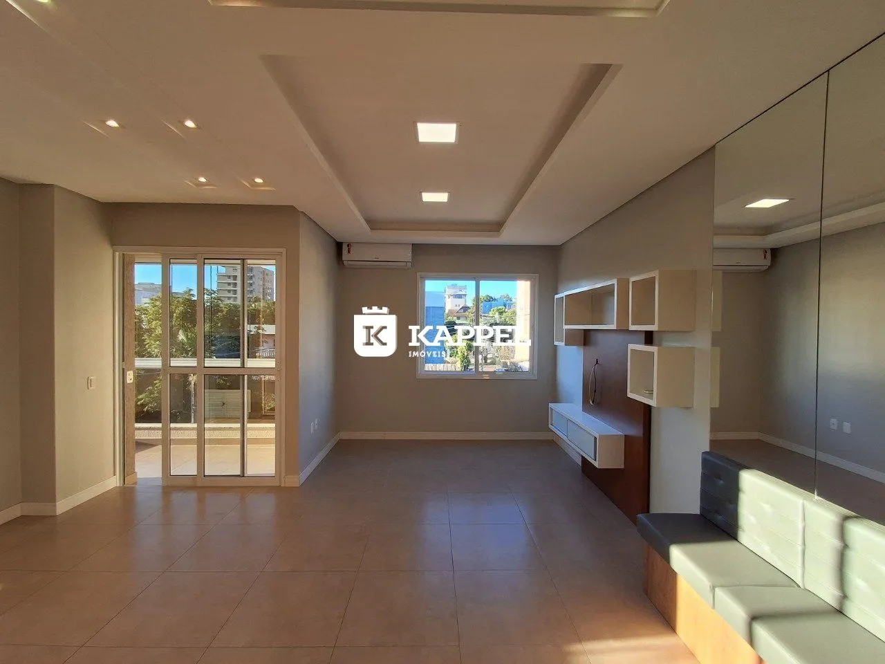 Sala de estar com piso claro e porta de vidro que oferece uma vista externa.