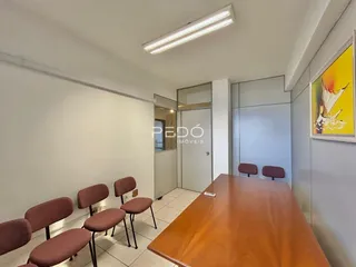 Ambiente interno de uma sala de jantar com mesa de madeira e cadeiras.