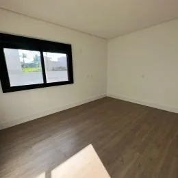 Foto de um cômodo interno com piso de madeira e janela.
