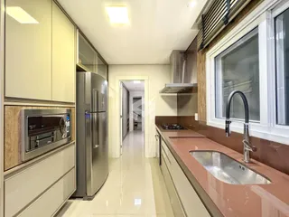 Vista da cozinha com armários e bancada em um imóvel no Brasil.