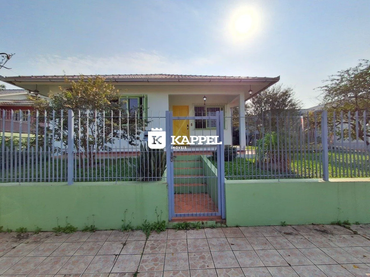 Foto da fachada de uma residência em Lajeado, Brasil, mostrando o muro e o portão de entrada.