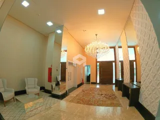 Ambiente interno de uma sala com piso de cerâmica e espelho grande.