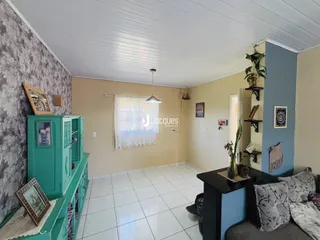 Ambiente interno de uma sala com piso de cerâmica branca e paredes amarelas claras.