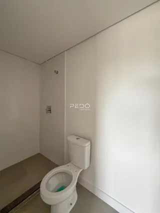 Foto de um banheiro com vaso sanitário e piso claro.