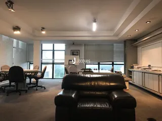 Uma sala de estar com sofá e grandes janelas.