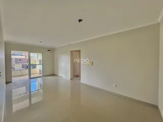 Espaço interno amplo com piso de cerâmica clara e paredes brancas.