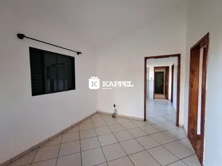 Sala de estar com piso de cerâmica clara e janela escura.