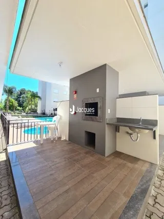 Vista da fachada de uma residência com deck de madeira.