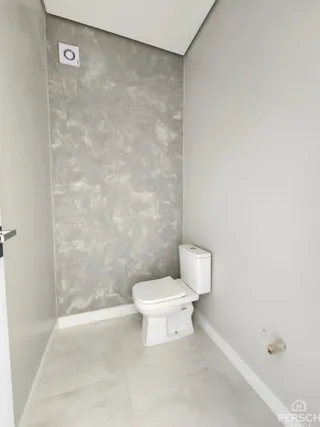 Foto de um banheiro com piso de cerâmica e vaso sanitário branco.