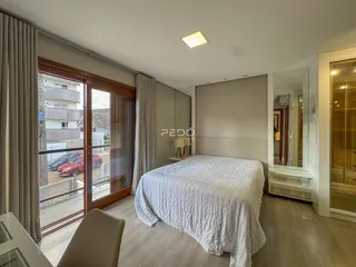 Quarto com porta de vidro abrindo para a área externa.