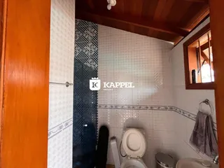 Foto interna de um banheiro com revestimento de azulejos brancos e azuis.
