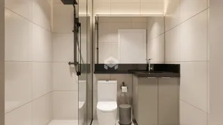 Interior de um banheiro moderno com revestimento cerâmico e box de vidro.
