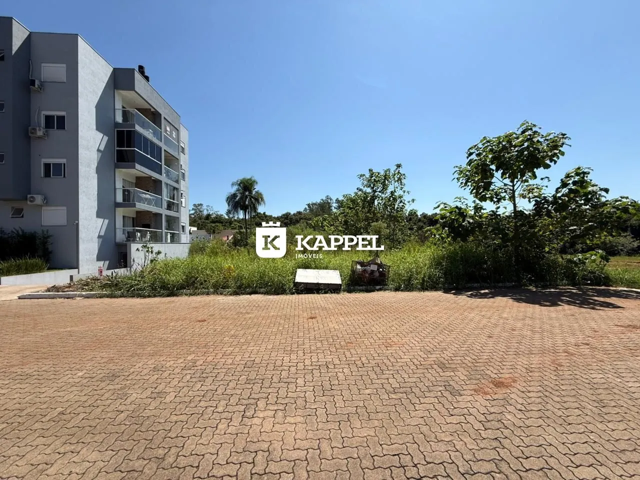 Fachada de um prédio residencial em Lajeado, Brasil, com área externa pavimentada.