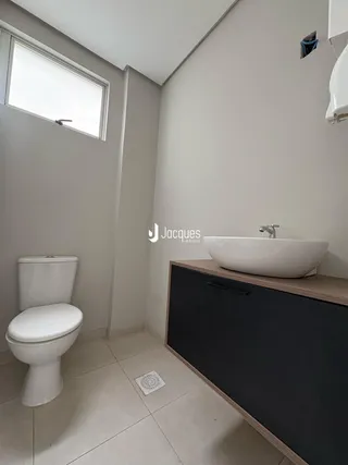 Foto de um banheiro moderno com vaso sanitário e pia de apoio.