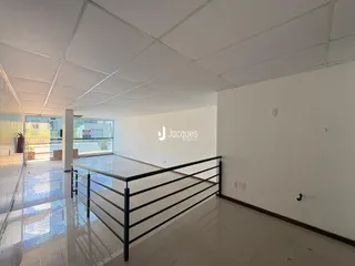 Corredor interno com piso de cerâmica e grade de segurança.