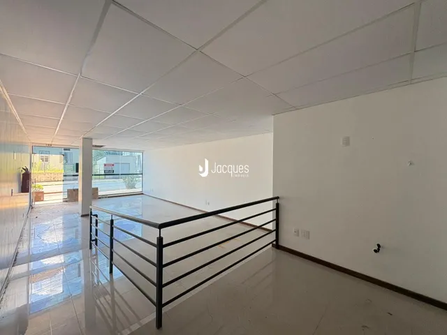 Corredor interno com piso de cerâmica e grade de segurança.