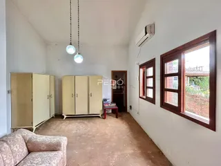 Interior de um ambiente com paredes brancas e piso de terra em uma residência.