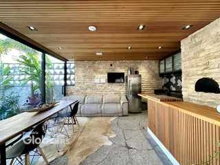 Sala de estar com vista para a vegetação e parede de pedra.
