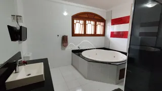 Banheiro com banheira e revestimento branco em imóvel em Lajeado.