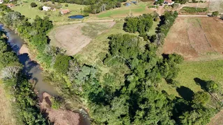Vista aérea de uma propriedade rural com vegetação densa e áreas de campo.