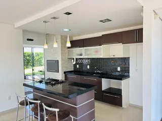 Vista da cozinha moderna com ilha e armários escuros em Lajeado.