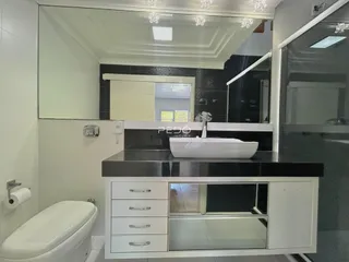 Foto de um banheiro moderno com bancada e vaso sanitário.