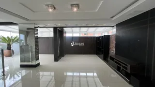 Sala de estar ampla com piso de porcelanato e teto alto.