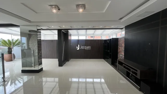 Sala de estar ampla com piso de porcelanato e teto alto.