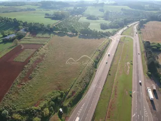 Vista aérea de campos agrícolas e uma estrada em uma paisagem rural.