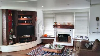 Sala de estar com lareira e painel de madeira em Lajeado.