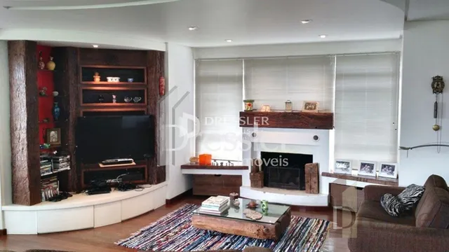 Sala de estar com lareira e painel de madeira em Lajeado.