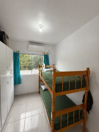 Quarto com cama de madeira e janela em uma residência.