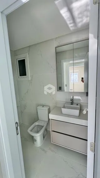 Foto de um banheiro com revestimento de mármore branco e bancada moderna.
